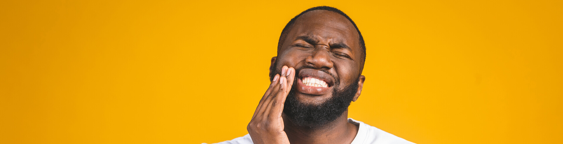 man holding his jaw in pain